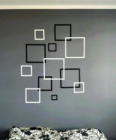 a black and white bed in a bedroom next to a wall with squares on it