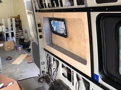 the inside of a vehicle with many electronics in it's storage area and boxes on the floor