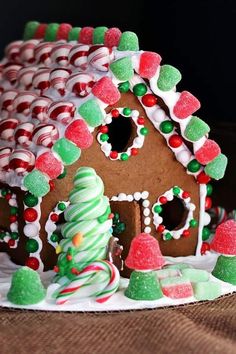 a gingerbread house decorated with candy canes and marshmallows for christmas