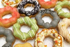 a bunch of doughnuts that are sitting on a table together in a pile