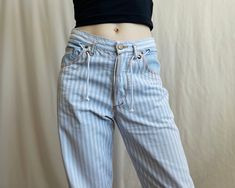 Vintage high waisted light blue and white vertically striped cotton pants. 5 pocket style, button fly, gently tapered legs. Feature a contrast stitching and a unique drawstring element integrated into the waistband. Back pockets integrated into the pant design with red X-shaped reinforcement stitches at the top corners and a label patch sewn onto the right pocket. ✏️ TAGS FIVE POCKET jeanswear 100% cotton Made in China Size 28 ✂️ CONDITION  Good vintage condition, few stains, faded spots under t Pocket Tags, Pant Design, Striped Denim, Denim Style, Pants Design, High Waisted Trousers, Cotton Pants, Contrast Stitch, Denim Fashion