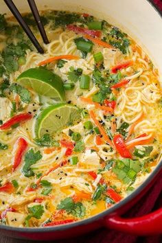 a red pot filled with noodles and vegetables