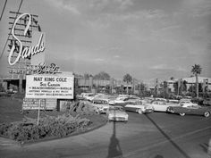 an old photo of cars driving down the street