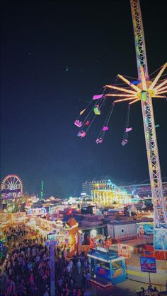 an amusement park at night with ferris wheel and rides