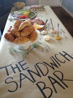 there is a table with food on it and the words sandwich bar written in large letters