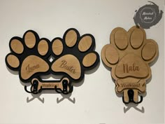 two wooden wall hooks with dog paw prints on them