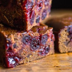 several pieces of brownies stacked on top of each other with cranberry toppings