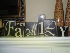 wooden blocks that spell out the word family on top of a fireplace mantel with candles