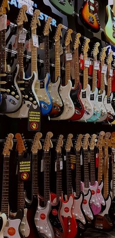 many electric guitars are on display in a store