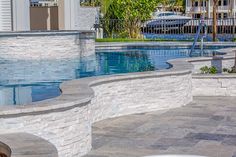 an empty swimming pool with steps leading to it and a palm tree in the background