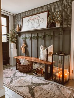 a room with a bench, rug and candles on the floor in front of it