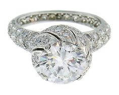 a white gold ring with diamonds on the sides and a center stone in the middle