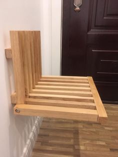 a wooden bed frame sitting on top of a hard wood floor next to a door