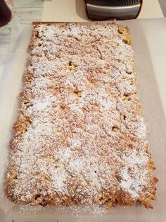 a cake sitting on top of a table covered in powdered sugar