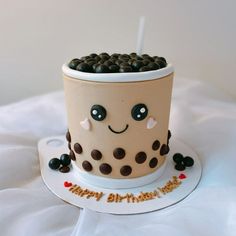 a birthday cake made to look like a coffee cup with chocolate chips on top and eyes