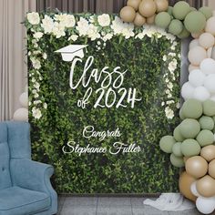 a graduation backdrop with balloons and greenery