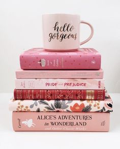 a stack of books with a coffee mug on top of them and the words hello gorgeous