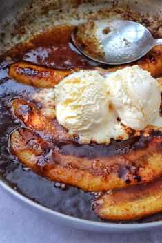 bananas and ice cream in a skillet with syrup on the side, ready to be eaten