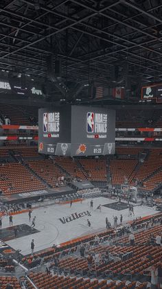 the inside of an arena with people playing basketball