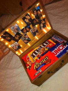 an open box filled with candy on top of a bed