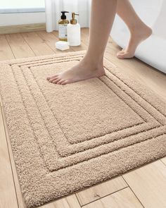 a person standing on top of a bathroom rug