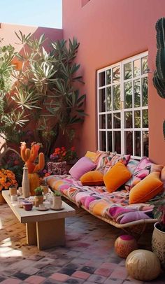 an outdoor living area with couches, potted plants and succulents