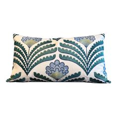 a blue and white pillow with an intricate design on the front, sitting against a white background