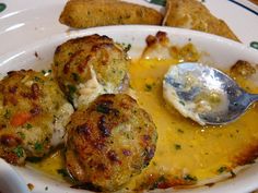 a white plate topped with crab cakes covered in cheese