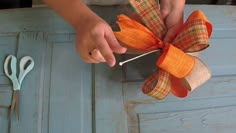 a person is tying a bow on a piece of wood