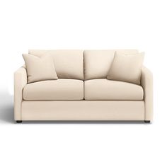 a white couch with four pillows on it's back and the seat upholstered