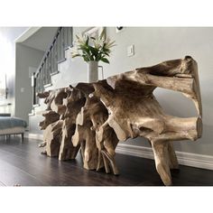 a wooden bench sitting on top of a hard wood floor next to a white wall