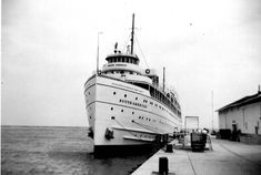 an old photo of a large boat docked in the water