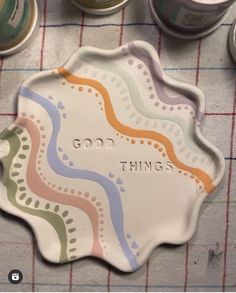 there is a plate that says good things next to some tins on the table