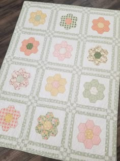 a quilted table topper with many different designs on it, including flowers and circles