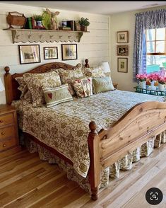 a large bed sitting inside of a bedroom on top of a hard wood floor next to a window