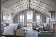 a bedroom with a large bed sitting next to two couches in front of a fireplace