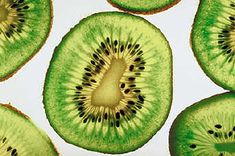 slices of kiwi fruit are arranged on a white surface