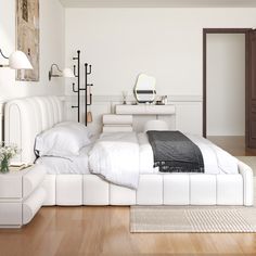 a white bed sitting on top of a wooden floor