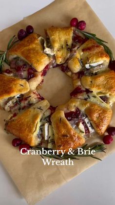 cranberry and brie wreath with rosemary sprigs on parchment paper, ready to be eaten