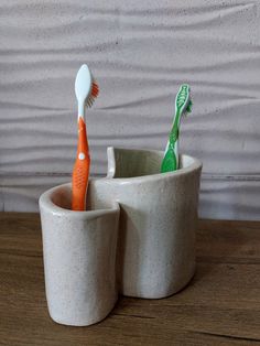 two toothbrushes in a cup on a table