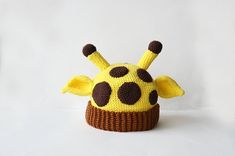 a knitted giraffe hat is shown on a white background with brown spots