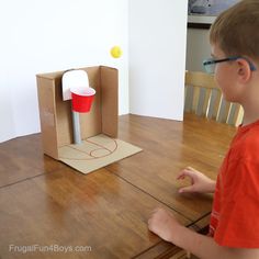 a young boy sitting at a table with a box on it