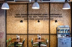 the inside of a restaurant with wooden tables and green chairs