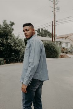 a young man standing in the middle of an empty street with his hands on his hips