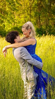 a woman in a blue dress hugging a man