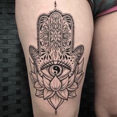 a woman's thigh with a hamsah tattoo on it and an eye in the middle