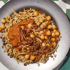 a plate filled with rice and beans on top of a green tablecloth covered table