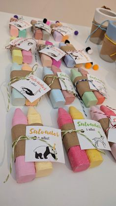 several different colored marshmallows are on the table with tags attached to them