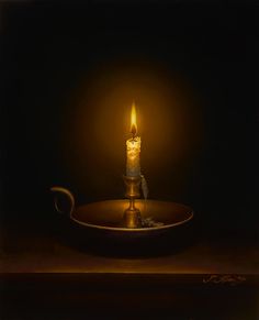 a lit candle sitting on top of a metal plate in the middle of a dark room