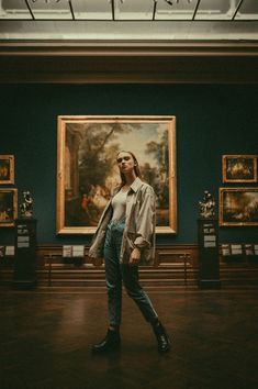 a woman standing in front of a painting